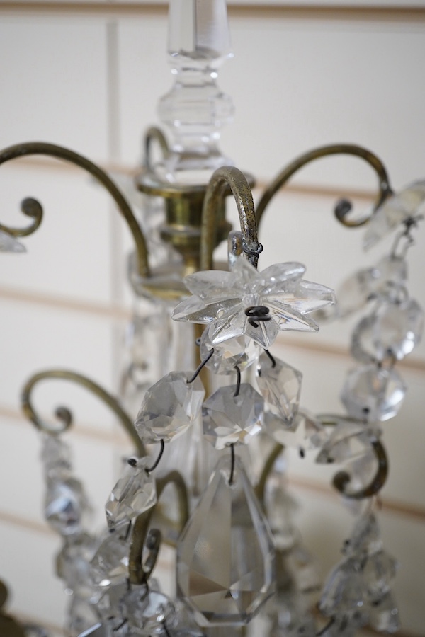 A pair of brass four branch candelabra with glass drops, 61cm high. Condition - fair